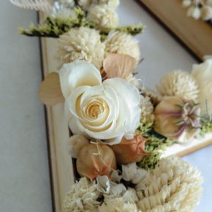 letras en madera y flor preservada